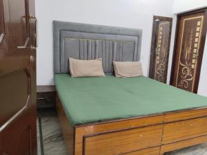 Un dormitorio con una cama con un colchón verde. en Hotel vishram, en Aligarh