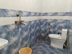 un baño con inodoro y lavabo en Hotel vishram, en Aligarh 4 fotos más