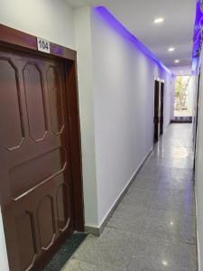 un pasillo con una puerta marrón y una pared blanca en Hotel vishram, en Aligarh