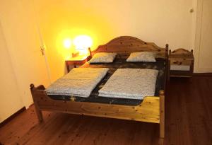 ein Schlafzimmer mit einem Holzbett mit zwei Kissen in der Unterkunft House in the middle of forests and lakes in Svartträsk