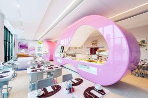 a pink restaurant with tables and a large mirror at nhow Berlin in Berlin +74 photos