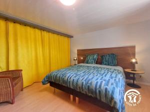 - une chambre avec un lit et un rideau jaune dans l'établissement La Maison d'à côté, à Mur-de-Barrez