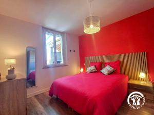 ein rotes Schlafzimmer mit einem großen Bett mit roten Wänden in der Unterkunft La Maison d'à côté in Mur-de-Barrez