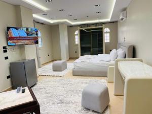 a bedroom with a bed and a flat screen tv at Desert Rose Hotel in Siwa
