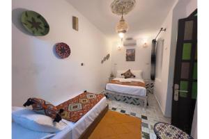 Un dormitorio con dos camas y un sofá. en Riad dar Saham, en Fez 46 fotos más