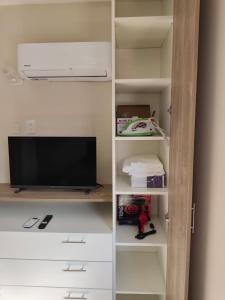 圣地亚哥-德尔埃斯特罗Departamento Centrico Santiago piso 1 Y 2的房间里有一台电视和一个书架