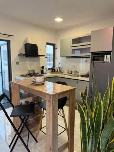 une cuisine avec une table en bois et quelques chaises dans l'établissement Sunset Views 3-Bedroom Apt, 1min Walk to Beach - NYHA1, à Flic-en-Flac