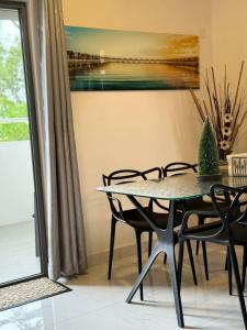 une salle à manger avec une table et des chaises et un tableau dans l'établissement Sunset Views 3-Bedroom Apt, 1min Walk to Beach - NYHA1, à Flic-en-Flac 49 autres photos