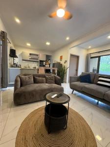 un salon avec un canapé et une table dans l'établissement Sunset Views 3-Bedroom Apt, 1min Walk to Beach - NYHA1, à Flic-en-Flac