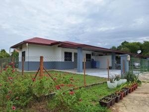 a house with a garden with flowers in the yard at Sofea Rania Homestay in Kota Belud