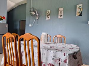 a table and chairs with a table and a fan at Sofea Rania Homestay in Kota Belud