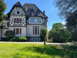an old house with a green lawn in front of it at Le Toit Sahler-Château Sahler XXᵉ in Exincourt