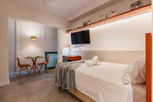 une chambre avec un lit et une table avec des chaises dans l'établissement Co. Next Liberdade - Av. Liberdade, à São Paulo 33 autres photos