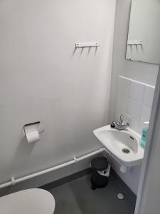 um banheiro branco com uma pia e um vaso sanitário em Kotimaailma - kolmio Kotkasta em Kotka