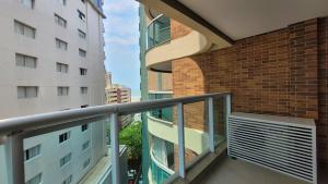 ein Balkon mit Geländer neben einem Backsteingebäude in der Unterkunft BookSantos Estanconfor 1007 - Perto do mar Gonzaga in Santos
