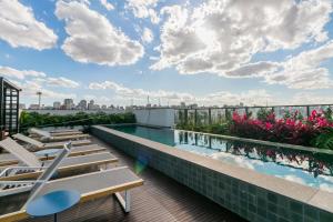 une piscine sur le toit d'un immeuble avec tables et chaises dans l'établissement Co. Next Liberdade - Av. Liberdade, à São Paulo