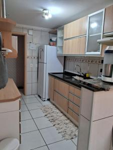 une cuisine avec un évier et un réfrigérateur dans l'établissement Apartamento no centro de Capão da Canoa, à Capão da Canoa