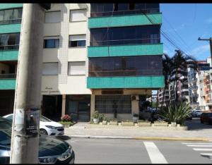 un bâtiment dans une rue de la ville avec une voiture garée devant dans l'établissement Apartamento no centro de Capão da Canoa, à Capão da Canoa
