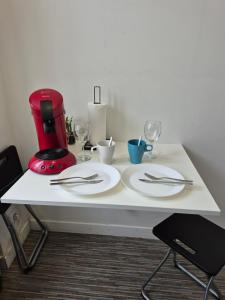 a white table with plates and wine glasses on it at 17, face à la gare in Lannion