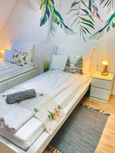 - une chambre avec 2 lits et une grande fresque murale dans l'établissement Magenta Apartman, à Mórahalom