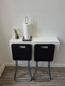 a white desk with two chairs and a lamp at 17, face à la gare in Lannion