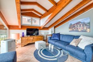ein Wohnzimmer mit einem blauen Sofa und einem Fernseher in der Unterkunft Villa Luce del Sol Lux with Pool - L - Happy Rentals in Albenga + 32 Fotos