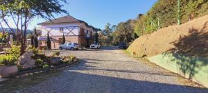 ein Haus mit einem Auto, das am Straßenrand geparkt ist in der Unterkunft Pousada Chales da Mantiqueira - Campos do Jordão in Campos do Jordão