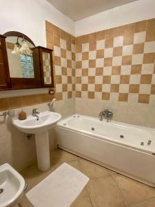 une salle de bains avec lavabo, baignoire et toilettes dans l'établissement Il Granaio del Barone, à Casal Velino