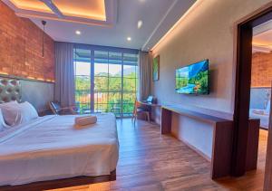 a hotel room with a bed and a tv at The Saray Munnar by VOYE HOMES in Anachal