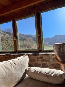 ein Zimmer mit zwei Kissen vor drei Fenstern in der Unterkunft Grange Mary in Le Falgoux
