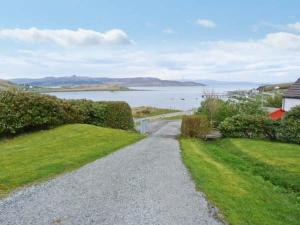 a gravel road leading to a lake with a house at MacKenzies Peak in Sconser