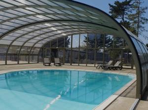a large swimming pool with a retractable roof at Le Cottage de Laura Jullouville 6 pers in Jullouville-les-Pins