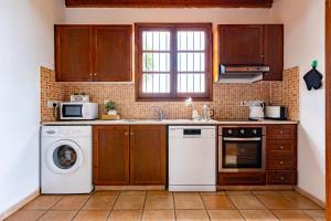 a kitchen with wooden cabinets and a washer and dryer at Ferienhaus In Polis Chrysochous Mit Offenem Kamin in Polis Chrysochous