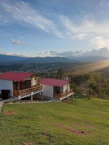 ein Haus auf einem üppigen grünen Feld in der Unterkunft Cabañas Villa Luz in San Agustín