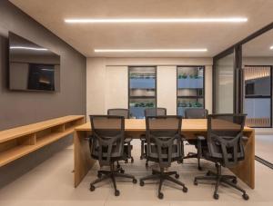 une salle de conférence avec une table et des chaises en bois dans l'établissement Beach Haus - Beira Mar - Let's AX Hospedagens, à João Pessoa 27 autres photos