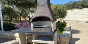 Un horno de piedra está en un patio. en גרין פארק - קוטג' מהמם עם בריכה מחוממת וג'קוזי בעין קנייא, en Ein Kinya