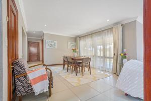 un salon avec une table et une salle à manger dans l'établissement Modern Family Haven with Garden Sleeps 8, à Sandton