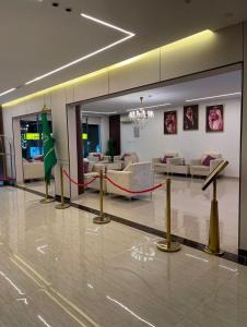 un hall d'entrée avec une salle d'attente ornée d'un ruban rouge dans l'établissement سفانة هلا للشقق المخدومة, à Hafr Al Baten