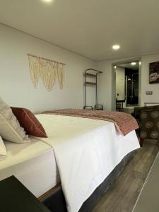 a bedroom with a large white bed in a room at Studio Refúgio in Ponta do Sol