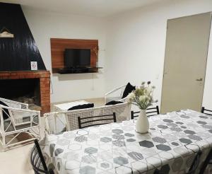 Una sala de estar con una mesa con un jarrón de flores encima. en Villa Carrizal, en Ciudad Lujan de Cuyo