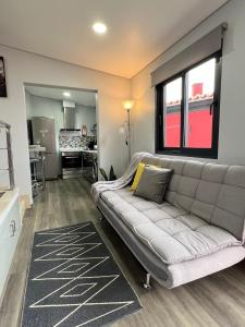 a living room with a couch and a kitchen at Studio Refúgio in Ponta do Sol