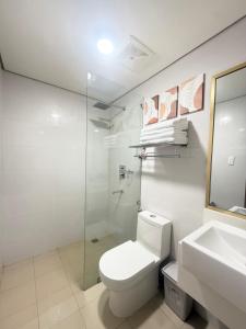 Un baño blanco con inodoro y lavabo. en The Banyan Rest, en Balibaguhan 18 fotos más
