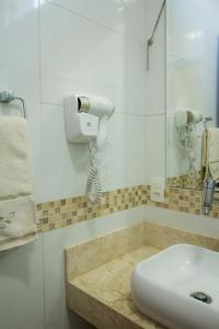 La salle de bains est pourvue d'un lavabo et d'un téléphone mural. dans l'établissement Casa de Campo em frente ao Lago em Americana-SP, à Americana