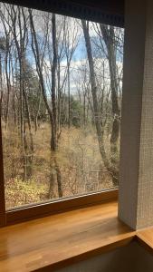 ein Fenster mit Waldblick in der Unterkunft 森の中で仲間や家族とゆっくり過ごせる温泉付コテージ 会員制別荘地で広大なプライベート空間 ペット可 那須高原りんどうハウス in Nasu