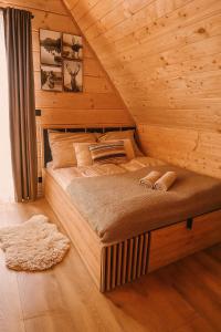 ein Schlafzimmer mit einem Bett in einer Blockhütte in der Unterkunft Chochołowski Zakątek in Chochołów