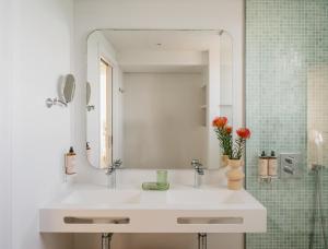 ein weißes Badezimmer mit Waschbecken und Spiegel in der Unterkunft MIM Mallorca Member of Melia Collection in Sa Coma