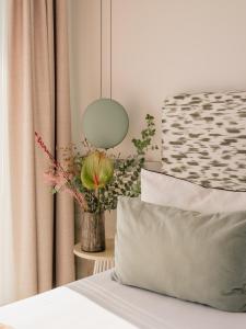 ein Bett mit einer Vase aus Blumen und einer Lampe in der Unterkunft MIM Mallorca Member of Melia Collection in Sa Coma