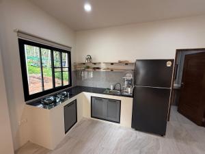 een keuken met een zwarte koelkast en een spoelbak bij Green Horizon in Ko Pha Ngan +3 foto's