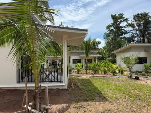 een wit huis met een palmboom ervoor bij Green Horizon in Ko Pha Ngan