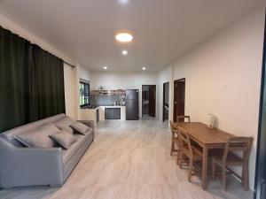 een woonkamer met een bank en een houten tafel bij Green Horizon in Ko Pha Ngan